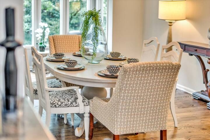 Dining table set for a shared meal beside large windows
