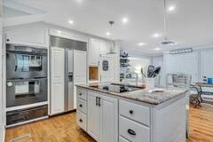 Bright kitchen with a large granite island and stainless appliances
